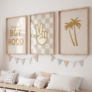 Könnte beinhalten: Eine helle Holz-Aufbewahrungsbank mit sechs weißen Aufbewahrungskisten. Die Bank ist mit einer Girlande aus pastellfarbenen Flaggen und drei gerahmten Drucken mit einem karierten Muster, einem Friedenszeichen und dem Text "long live boyhood" verziert.