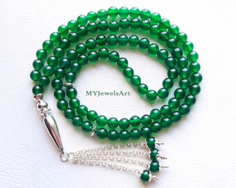 Può includere: Una collana di perline verdi brillanti con un nappa argentata. Le perline sono di un verde brillante e la nappa ha un design intricato. Le perline sono disposte a cerchio. Il testo "MYJewelsArt" è visibile.