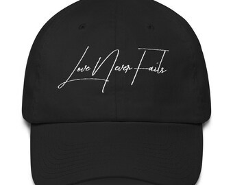 May include: Black baseball cap with a white embroidered cursive inscription that reads "Love Never Fails".