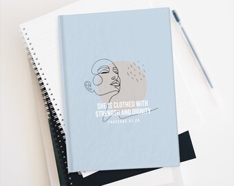 May include: A light blue journal with a line drawing of a woman's face and the text "She is clothed with strength and dignity, Proverbs 31:25".