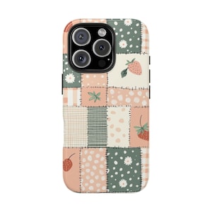 May include: A phone case with a patchwork design featuring strawberries, daisies, and other floral and geometric patterns in shades of pink, green, and cream. The case has a black camera module.