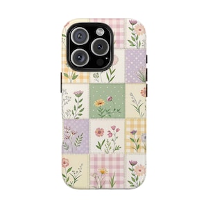 May include: A floral phone case featuring a patchwork design with various pastel-colored squares. Each square showcases a different floral illustration, including daisies, wildflowers, and other blooms. The case has a black border and a camera cutout.