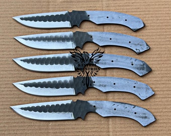 May include: Five unfinished knife blades with a hammered finish. The blades are arranged in a row, with the tips pointing to the right. The blades are made of metal and have a gray color.