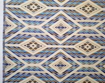 May include: A fabric with a geometric pattern of blue, brown, and white diamonds. The fabric has a woven texture and a subtle sheen.