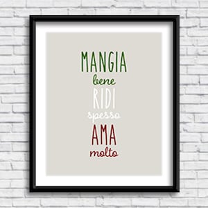 May include: A framed print with a white background and black frame. The print features the Italian phrase "Mangia bene, ridi spesso, ama molto" in green, white, and red lettering.