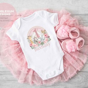 May include: White baby onesie with a pink and green jungle animal design and the text "1st Birthday".