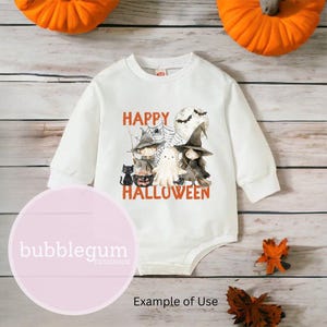May include: White long-sleeved baby onesie with a graphic print of a ghost, two witches, a black cat, and a pumpkin. The text "Happy Halloween" is printed in orange on the onesie.