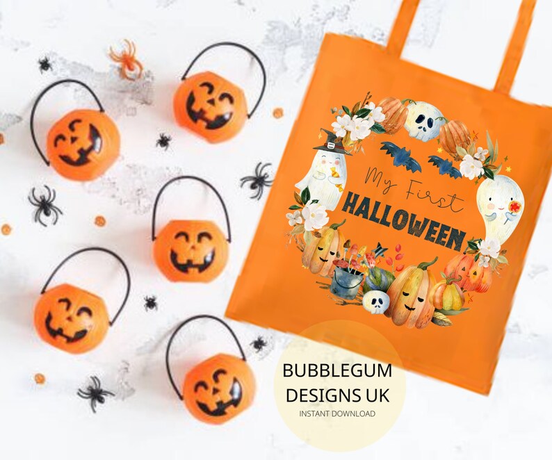 Pode incluir: Sacola de tecido laranja e branca com o texto "My First Halloween" e uma ilustra&ccedil;&atilde;o em aquarela de ab&oacute;boras, fantasmas e morcegos. A sacola tem um fundo branco e o texto est&aacute; em preto.