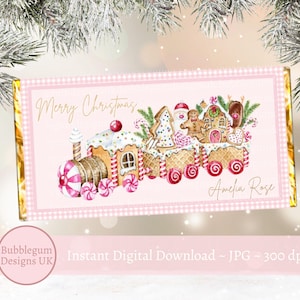 Könnte beinhalten: Ein rosa-goldener, druckbarer Weihnachts-Schokoladenriegel-Wrapper mit einem Lebkuchenhaus-Zug mit Zuckerstangen und dem Text "Frohe Weihnachten" und "Amelia Rose".