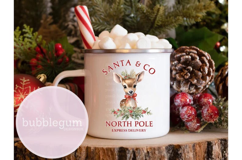 K&ouml;nnte beinhalten: Wei&szlig;e Emaille-Tasse mit einer rot-gr&uuml;nen Illustration eines Rehs mit einer roten Schleife. Die Tasse tr&auml;gt den Schriftzug "Santa & Co. Nordpol Expresslieferung".