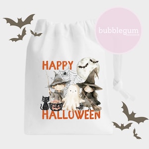 May include: White drawstring bag with a Halloween design featuring two children dressed as witches, a ghost, a black cat, and a cauldron. The text "Happy Halloween" is printed in orange on the bag.