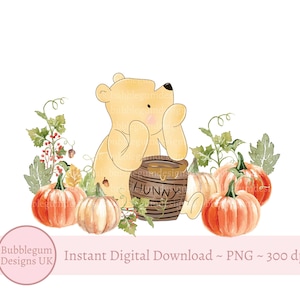 May include: A cartoon bear wearing a yellow shirt sits next to a honey pot labeled "Hunny". The bear is surrounded by pumpkins and fall foliage.