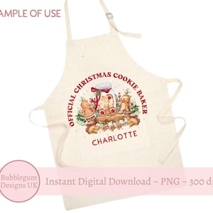 Puede incluir: Un delantal blanco con el texto "Official Christmas Cookie Baker" en rojo y el nombre "Charlotte" en rojo. El delantal presenta una ilustración de acuarela de un frasco de galletas con hombres y mujeres de jengibre.