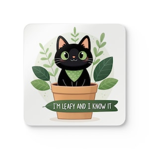 Puede incluir: Posavasos cuadrado con un gato negro de dibujos animados con ojos verdes y una bandana verde, sentado en una maceta de terracota. El gato está rodeado de hojas verdes y el texto dice "I'M LEAFY AND I KNOW IT".