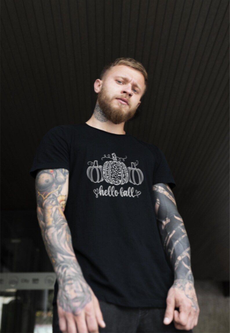 May include: A black t-shirt with a white graphic of three pumpkins and the text "hello fall" in a cursive font.