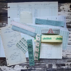 May include: A collection of vintage paper ephemera, including tickets, receipts, and a small gridded notebook. The tickets are green and white with the text "Eintrittskarte" and "Jetlink". The notebook is green and white with a grid pattern.