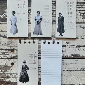 May include: Five small, spiral bound notebooks with black covers. Each notebook has a different image of a woman on the front. The images are in black and white. The notebooks have handwritten numbers and text on the front.