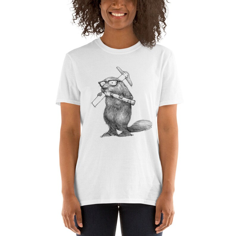 May include: White t-shirt featuring a detailed black and white illustration of a beaver wearing glasses and holding a pickaxe and a rolled-up document. The beaver is standing upright. The t-shirt is a short-sleeved style.