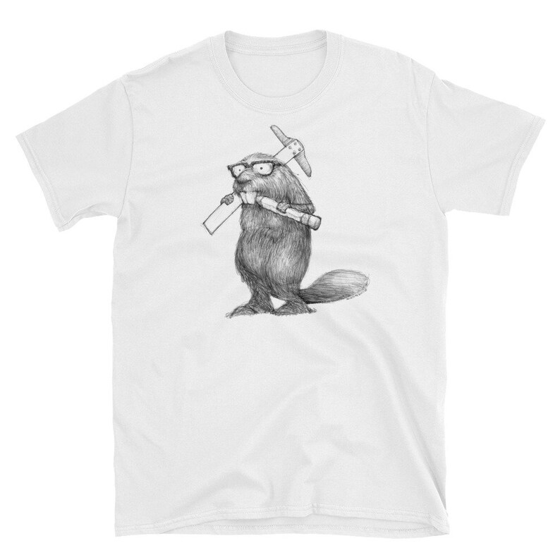 May include: White t-shirt featuring a detailed pencil sketch of a beaver wearing glasses and holding a pickaxe and a rolled-up document. The beaver is standing upright, with its tail visible. The design is centered on the shirt.