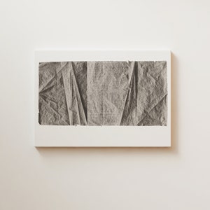 K&ouml;nnte beinhalten: Ein Schwarzwei&szlig;-Abstrakt-Kunstdruck mit einem strukturierten, zerknitterten Papierdesign. Der Druck ist in einem wei&szlig;en Rahmen gerahmt und h&auml;ngt an einer wei&szlig;en Wand.