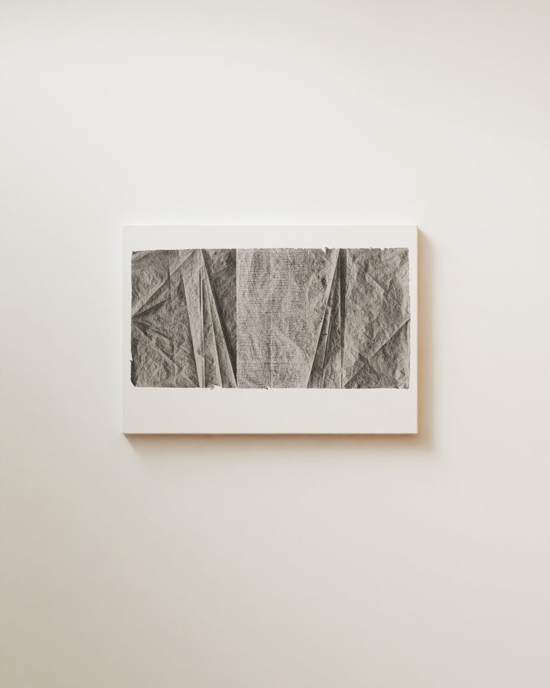 K&ouml;nnte beinhalten: Ein Schwarzwei&szlig;-Abstrakt-Kunstdruck mit einem strukturierten, zerknitterten Papierdesign. Der Druck ist in einem wei&szlig;en Rahmen gerahmt und h&auml;ngt an einer wei&szlig;en Wand.