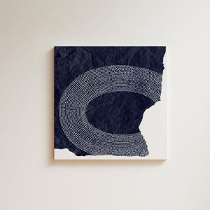May include: A dark blue canvas painting with a white dotted design in the shape of a crescent moon.