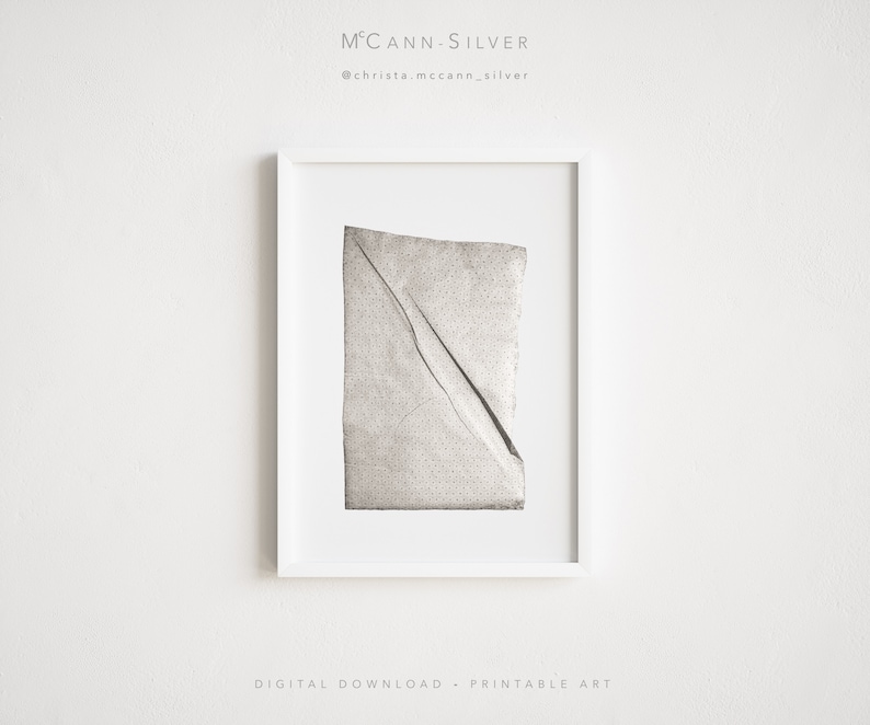 May include: A black and white photograph of a piece of crumpled paper with a dotted pattern. The paper is framed in a white frame. The image is titled "McCann-Silver" and includes the social media handle "@christa.mccann_silver".