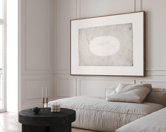 May include: A black round coffee table with a fluted base sits on a wood floor in a living room. A white sofa with a pillow sits in the background. A framed abstract print hangs on the wall.