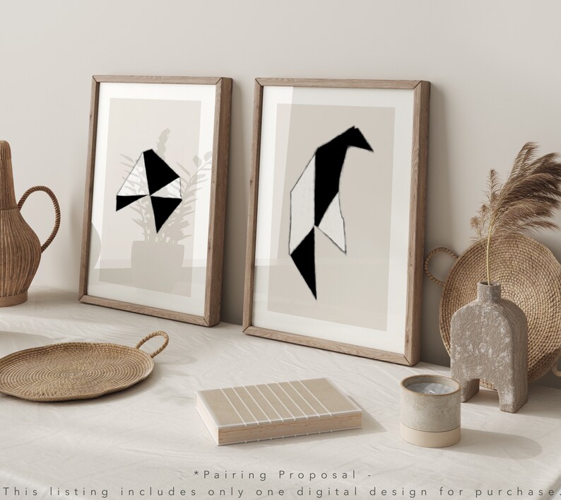 May include: Two framed abstract geometric art prints with black and white shapes on a beige background. The prints are in wooden frames and are displayed on a white surface.