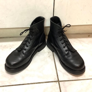 May include: A pair of black leather ankle boots featuring a rounded toe, a lace-up front with black eyelets, and black laces. The boots have a solid black sole and a smooth finish, providing a clean and functional design for everyday footwear.