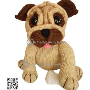 Può includere: Un giocattolo a forma di carlino fatto a mano, lavorato a maglia, nei colori beige, marrone e rosa. Il carlino ha grandi occhi neri, un muso marrone e orecchie flosce. Il giocattolo è seduto con un osso bianco. Il testo "A Crafty Life by Mandy" è visibile.