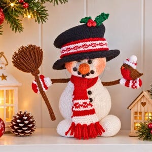 May include: A crocheted snowman figurine wearing a black top hat with a red and white band, a red and white fringed scarf, and black buttons. The snowman holds a brown yarn broom in one hand and a small red and brown bird in the other.