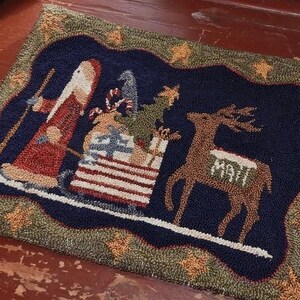 Peut inclure: Tapis de Noël rectangulaire avec un fond bleu marine représentant le Père Noël dans un traîneau, un renne avec "MAIL" sur le côté et une bordure décorative. Le tapis est en matériau tissé avec un aspect texturé.