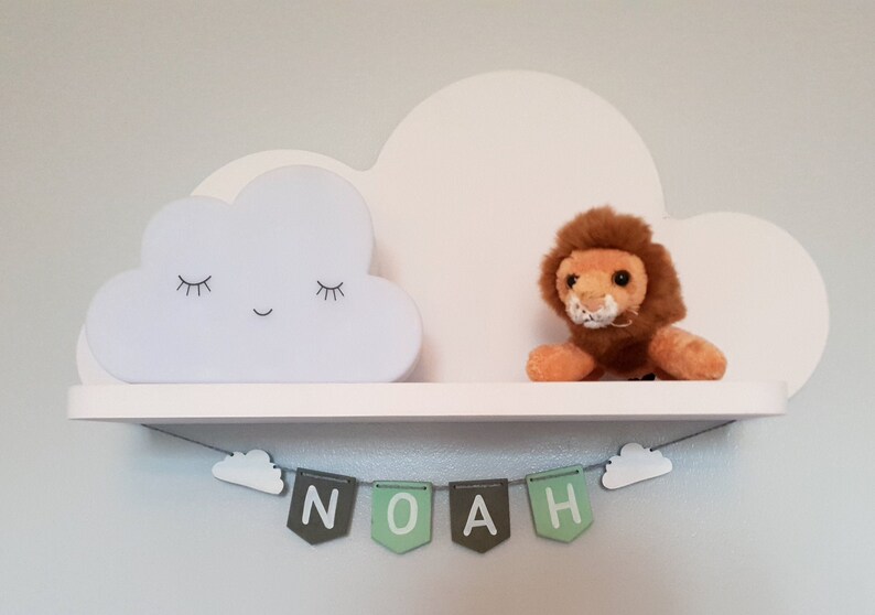 May include: White cloud shelf with a sleeping cloud nightlight, a stuffed lion, and a green and gray banner that reads "NOAH".