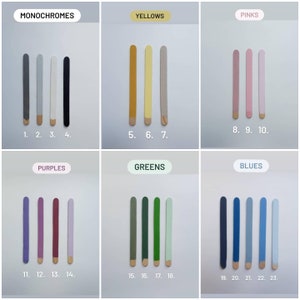 May include: A chart with 23 color swatches arranged in rows labeled "Monochromes", "Yellows", "Pinks", "Purples", "Greens", and "Blues". Each color swatch is a wooden stick painted with a different shade of the color group.