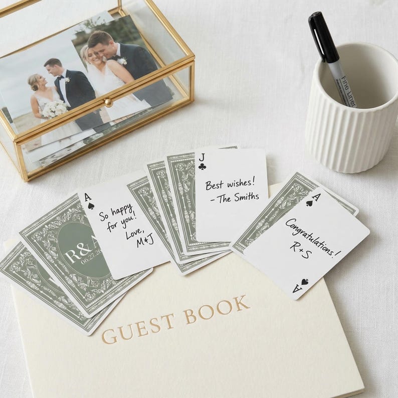 May include: A white ceramic mug with a black handle and the text "But First, Coffee" in a handwritten style. The mug is on a white surface. The mug is approximately 4 inches tall.