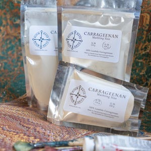 May include: Three clear plastic bags of Carrageenan marbling size, with white labels and the Four Keys Book Arts logo. The bags contain a white powder and a solid block. A tube of paint and a paintbrush are in the foreground.