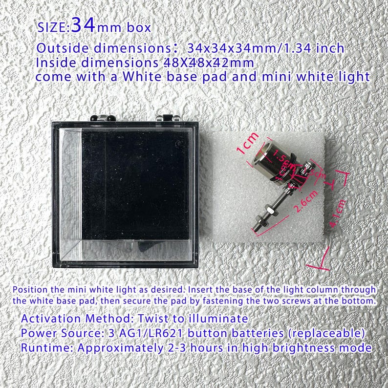 May include: A clear, square display box with a black interior, next to a small, silver and red light fixture on a white pad. The box measures 1.34 inches on each side. The light fixture is 2.6 cm long. Text on the image provides additional details.