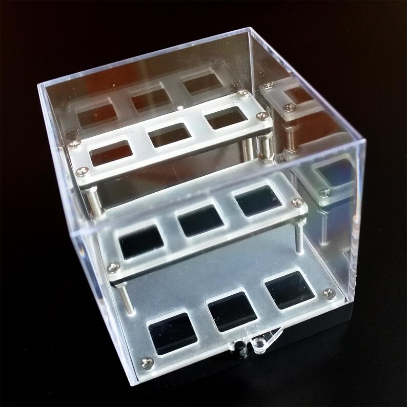 May include: A clear plastic display case with three tiers of metal shelves. Each shelf has six square openings for displaying small items.