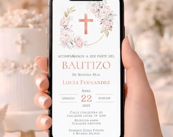 May include: A smartphone displaying a baptism invitation. The invitation features a cross and floral design in pink and white, with text in Spanish. The phone is held in a hand, with a blurred background of white decorations.
