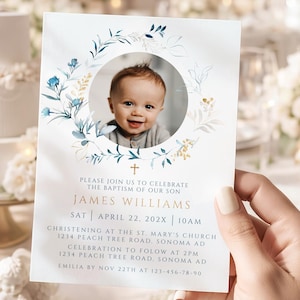 May include: A baptism invitation card featuring a baby's photo within a floral wreath. The card includes the text "James Williams" and event details. The design incorporates blue and gold accents, with a cross symbol.