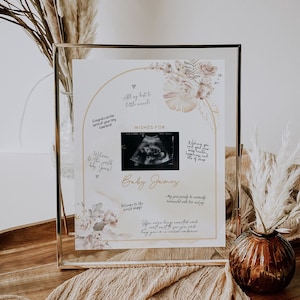 Puede incluir: Una tarjeta blanca con un diseño floral y una imagen de ultrasonido, enmarcada en oro. La tarjeta dice "Deseos para el bebé James" e incluye el texto "Todo lo mejor para el pequeño milagro".