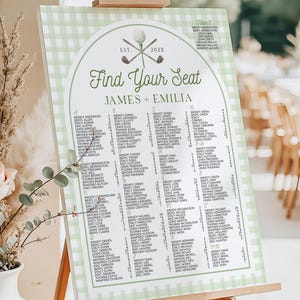 May include: A rectangular wedding seating chart sign with a light green and white gingham border. The sign features the text Find Your Seat, James + Emilia, and a golf-themed graphic. It is displayed on a wooden easel stand.