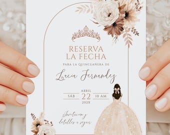 May include: A white card with a floral design and a crown. The text on the card reads "Reserva la Fecha" for a quinceañera for Lucia Fernandez on Saturday, April 22, 202X at 10 AM.