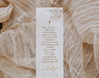 Peut inclure: Une carte d'annonce de baptême rectangulaire avec une croix et un motif floral. La carte contient du texte en espagnol, dont "mi bautizo" et la date "24 ABRIL 202x". La carte est posée sur un tissu beige texturé.