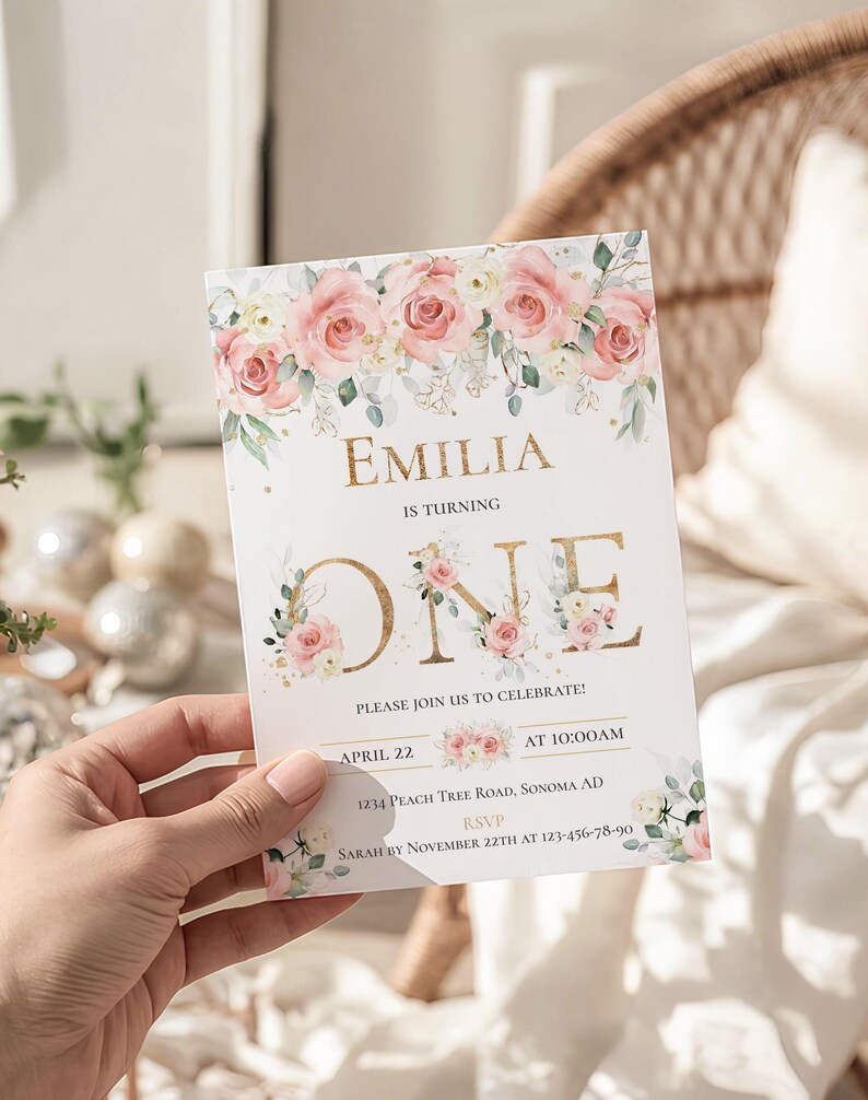 May include: A rectangular birthday invitation card featuring a floral border of pink roses and green leaves at the top. The text reads EMILIA IS TURNING ONE, PLEASE JOIN US TO CELEBRATE, APRIL 22 AT 10:00AM, 1234 PEACH TREE ROAD, SONOMA AD, RSVP SARAH BY NOVEMBER 22TH AT 123-456-78-90.
