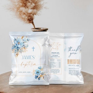 May include: A light blue and gold baptism favour bag with a cross, floral design, and the text "JAMES baptism APRIL 24TH, 202X". The back of the bag has a nutrition facts label with the text "SERVING SIZE: 1 SWEET CHILD CALORIES: 100% PURE LOVE" and the text "thank you APR 24TH, 202X INGREDIENTS: ONE BLESSED CHILD FULL OF JOY, FAITH, LOTS OF LOVE, HUGS, KISSES FROM FAMILY AND FRIENDS".