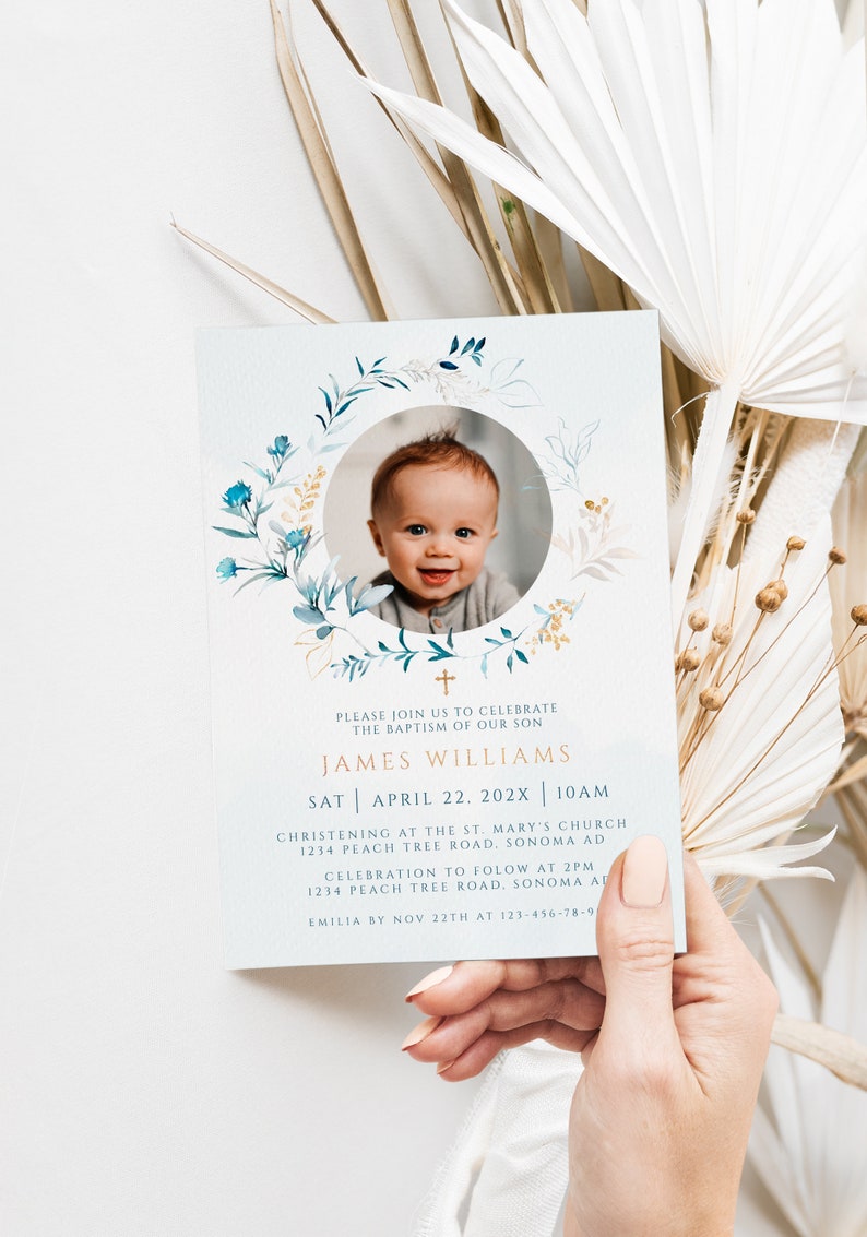 May include: Baptism invitation featuring a smiling baby's photo surrounded by a floral wreath. The invitation includes the name James Williams, date, time, and location details. The text is in a gold color.