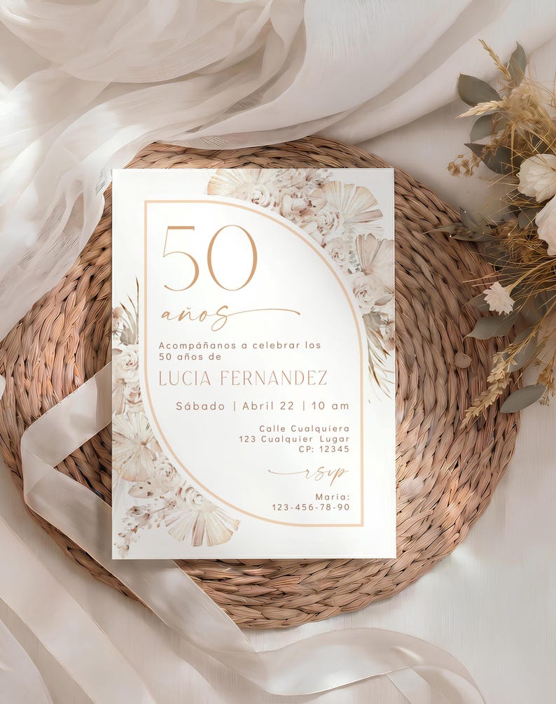 May include: A rectangular invitation card featuring a gold arch outline, floral illustrations, and the text 50 a&ntilde;os, Acomp&aacute;&ntilde;anos a celebrar los 50 a&ntilde;os de LUCIA FERNANDEZ, S&aacute;bado | Abril 22 | 10 am, Calle Cualquiera 123 Cualquiera Lugar CP: 12345, rsvp, Maria: 123-456-78-90.