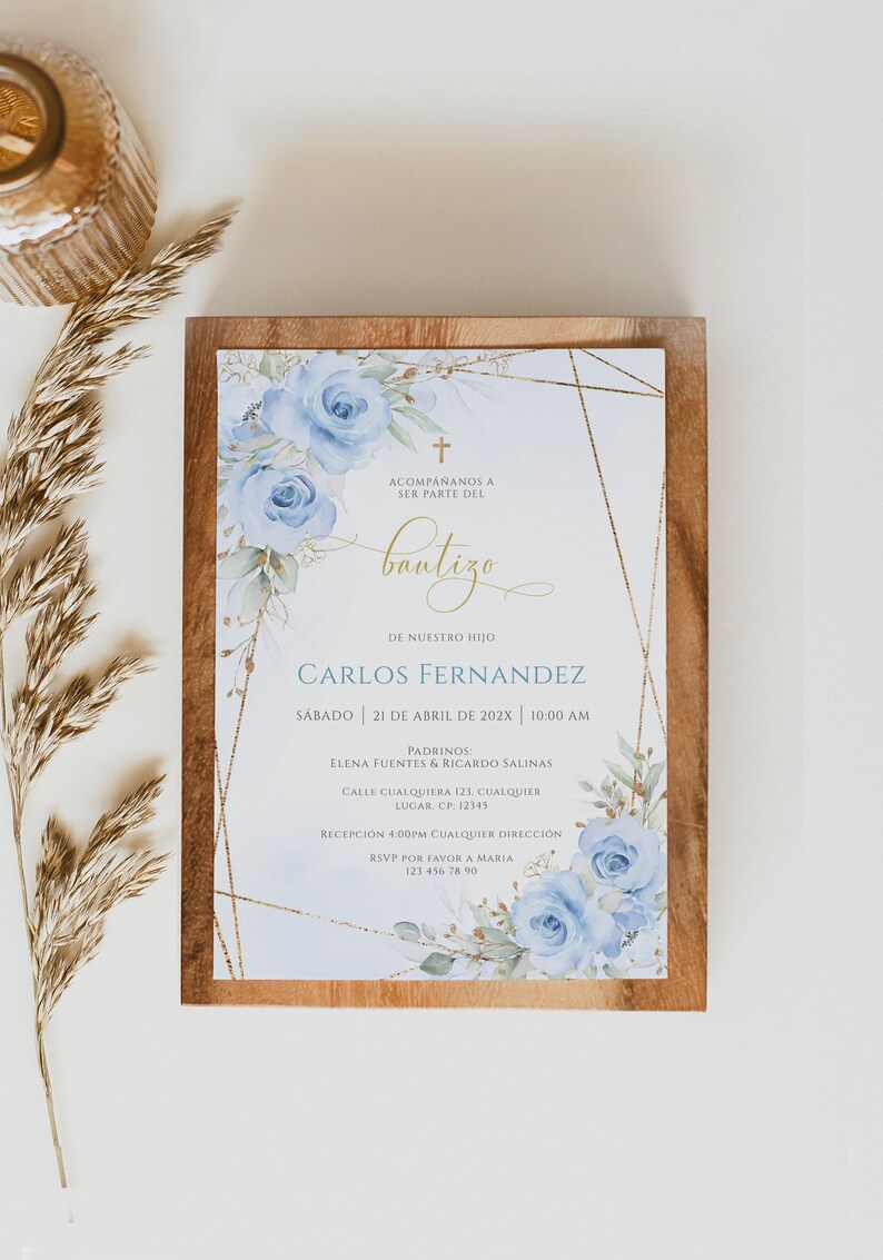May include: A blue and gold baptism invitation with a watercolour floral design. The invitation includes the text "Acompa&ntilde;anos a ser parte del bautizo de nuestro hijo Carlos Fernandez Sabado 21 de Abril de 202X 10:00 AM Padrinos: Elena Fuentes & Ricardo Salinas Calle Cualquier 123. Cualquier Lugar. CP: 12345 Recepcion 4:00PM Cualquier Direccion RSVP por favor a Maria 123 456 78 90"